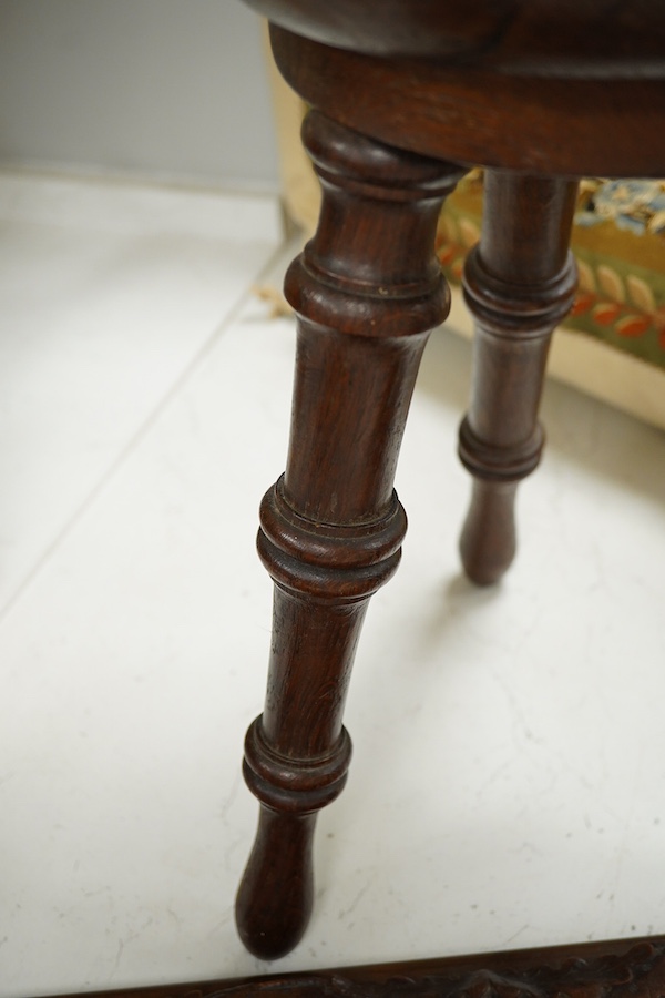 A Black Forest carved book-rack and a commemorative carved oak stool, for the Winchester college emblem, stool 39cm high